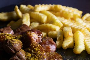 Currywurst (salsiccia a rondelle con salse, curry e patatine)