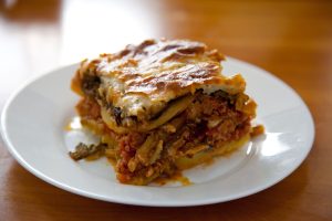 Moussaka, piatto gratinato a base di melanzane, patate, carne macinata (solitamente di agnello o manzo), salsa di pomodoro e besciamella